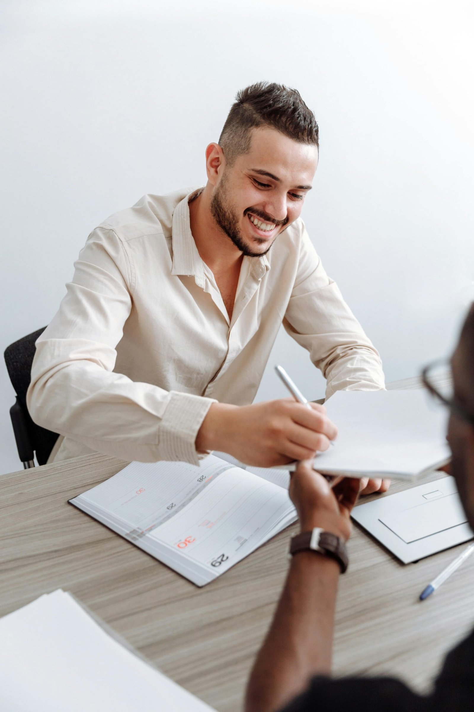 A cheerful office meeting with professionals exchanging documents and ideas.