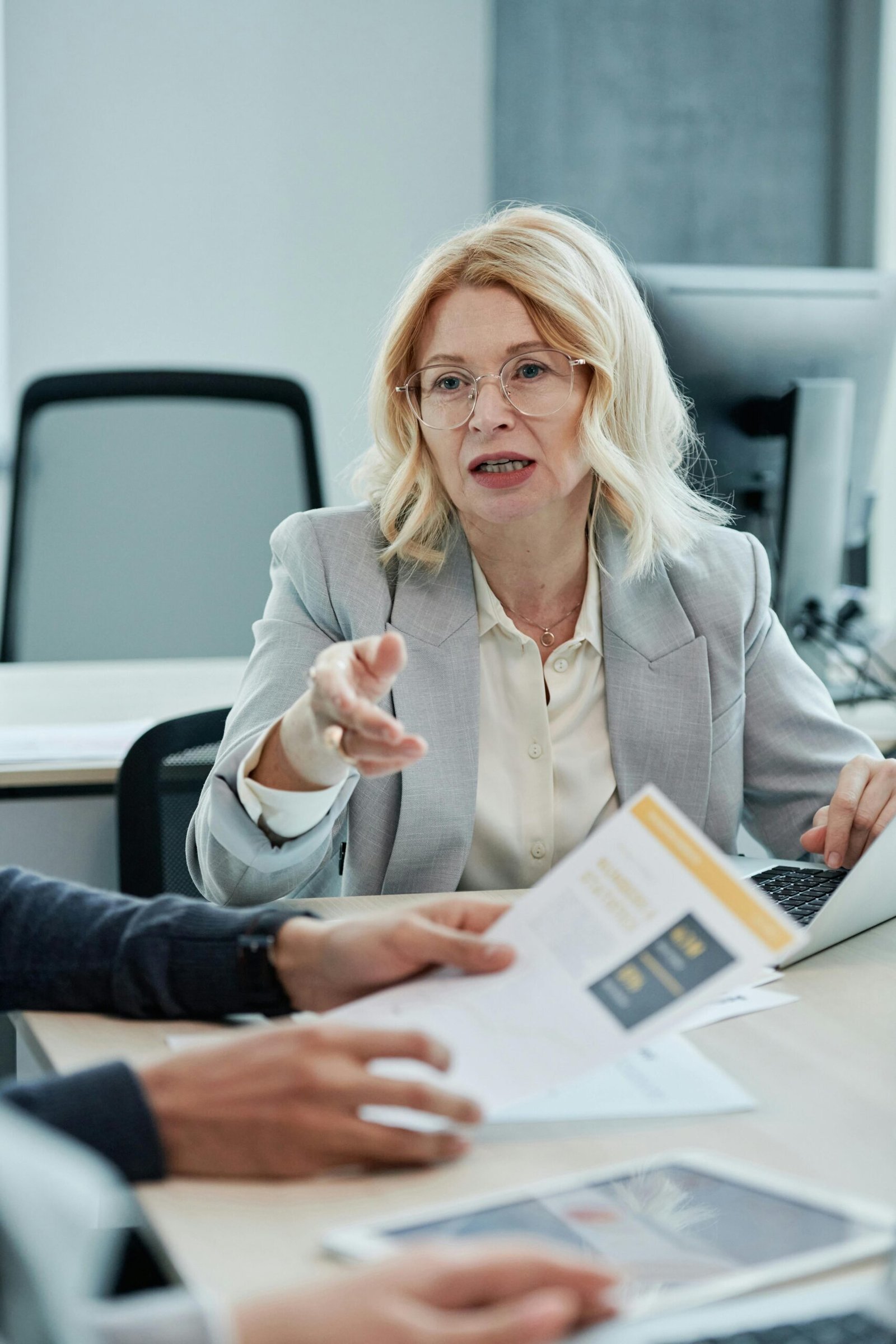Professional woman engaged in a business meeting, discussing and analyzing documents.